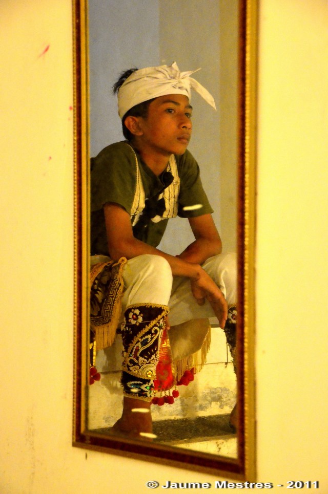 L’aleví de la família del mestre Anom Agung reflectit al mirall. A mig abillar, abans d’interpretar la dansa amb màscara Jauk Keras.