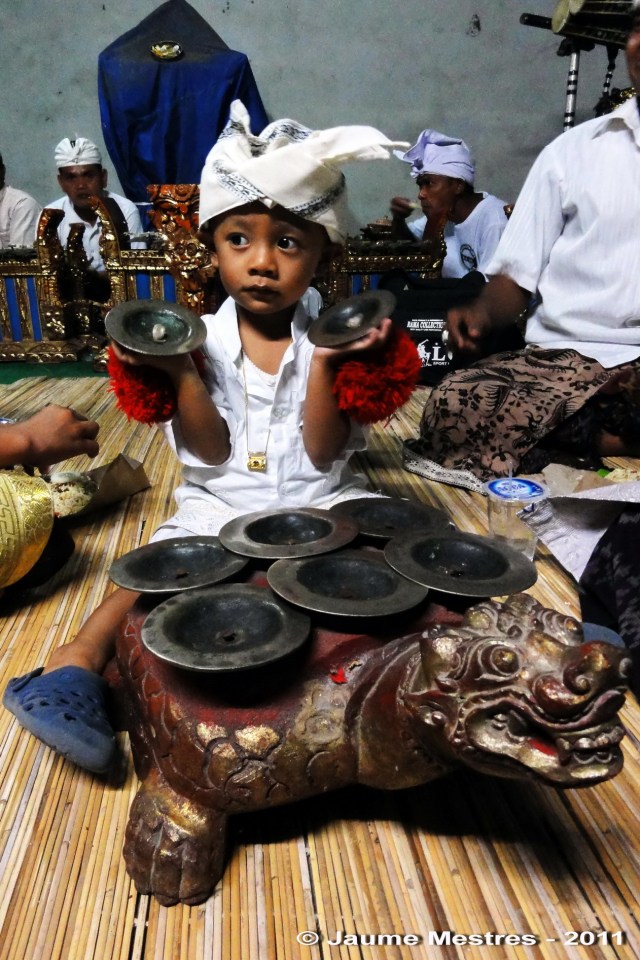 El fill d’un músic de gamelan practicant amb els platerets durant una nit de cerimònia al temple Pura Penataran, de Pengosekan.
